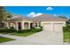 Charming home with a well-manicured lawn, lush landscaping, and an inviting covered entrance leading to a spacious two-car garage at 4918 Wildwood Pointe Rd, Winter Garden, FL 34787