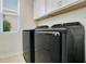 Well-lit laundry area featuring tile floors, modern appliances and overhead storage cabinets, offering convenience and organization at 4918 Wildwood Pointe Rd, Winter Garden, FL 34787
