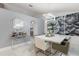 Dining area with a modern white table, gray chairs, marble floors, contemporary lighting, and stylish decor at 512 Yellow Tail Pl, Chuluota, FL 32766