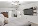 A cozy bedroom featuring a mounted TV, sliding barn door, and ensuite bath and vanity area at 512 Yellow Tail Pl, Chuluota, FL 32766