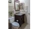 Bathroom featuring a granite vanity with a decorative mirror, complemented by tiled walls and modern fixtures at 5661 Parkview Lake Dr, Orlando, FL 32821