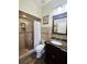 Bathroom features a tiled shower with built-in shelving and seat, complemented by a granite vanity and wood-look flooring at 5661 Parkview Lake Dr, Orlando, FL 32821