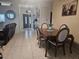 Open-concept dining area featuring a wood table, upholstered chairs, and view into the foyer at 5661 Parkview Lake Dr, Orlando, FL 32821