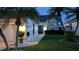Charming home exterior with palm trees, landscape lighting, and well-kept lawn at 5661 Parkview Lake Dr, Orlando, FL 32821