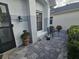 Close-up of entrance featuring potted plants, outdoor lighting, and a black iron bench at 5661 Parkview Lake Dr, Orlando, FL 32821