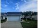 Beautifully maintained single-story home with an attached garage and tropical landscaping at 5661 Parkview Lake Dr, Orlando, FL 32821
