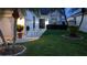 Inviting home exterior at dusk features a lush lawn, palm trees, and lighting at 5661 Parkview Lake Dr, Orlando, FL 32821