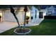 Home's front exterior featuring a well-manicured lawn, palm trees, and exterior lighting at 5661 Parkview Lake Dr, Orlando, FL 32821