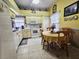 Well-lit kitchen with white cabinets, appliances, and a cozy dining area with seating for four at 5661 Parkview Lake Dr, Orlando, FL 32821