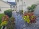 A brick paver walkway with a black metal bench, colorful plants, and trimmed green bushes at 5661 Parkview Lake Dr, Orlando, FL 32821