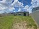 Fenced backyard with lawn, patio, and house with solar panels under a sunny sky at 568 Meadow Bend Dr, Davenport, FL 33837