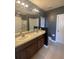 Bathroom featuring dual sinks, a large mirror with vanity lights, and tile floors at 568 Meadow Bend Dr, Davenport, FL 33837