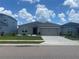 Beautiful single-story home featuring a gray exterior, a two-car garage, and manicured landscaping at 568 Meadow Bend Dr, Davenport, FL 33837