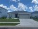 Beautiful single-story home featuring a gray exterior, a two-car garage, and manicured landscaping at 568 Meadow Bend Dr, Davenport, FL 33837