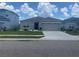 Beautiful single-story home featuring a gray exterior, a two-car garage, and manicured landscaping at 568 Meadow Bend Dr, Davenport, FL 33837
