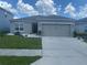 Charming single-story home featuring a gray exterior, a two-car garage, and well-maintained landscaping at 568 Meadow Bend Dr, Davenport, FL 33837