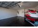 A well-lit garage with a sleek epoxy floor, providing ample space for vehicles and storage, along with a jet ski at 568 Meadow Bend Dr, Davenport, FL 33837