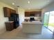 Well-lit kitchen features an island, dark cabinetry, and stainless steel appliances at 568 Meadow Bend Dr, Davenport, FL 33837