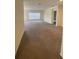 Open-plan living room featuring neutral walls, carpeting, and a large window at 568 Meadow Bend Dr, Davenport, FL 33837