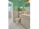 Stylish bathroom with a marble-tiled shower and tub, gray vanity, a round mirror, and green walls at 760 Bearcreek Dr, Bartow, FL 33830