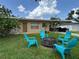 Inviting backyard featuring a cozy fire pit area surrounded by colorful Adirondack chairs, perfect for outdoor gatherings at 760 Bearcreek Dr, Bartow, FL 33830