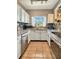 Well-lit kitchen featuring white cabinets, stainless steel appliances, and a window over the sink with a view of greenery at 760 Bearcreek Dr, Bartow, FL 33830