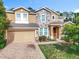 Inviting two-story home showcasing a beautiful stone facade and a well-manicured front yard at 771 Cavan Dr, Apopka, FL 32703