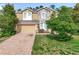 Charming two-story home featuring a stone facade, brick driveway, and lush landscaping at 771 Cavan Dr, Apopka, FL 32703