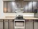 Modern kitchen features dark cabinets, granite countertops, and stainless steel appliances at 771 Cavan Dr, Apopka, FL 32703