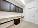 Well-lit laundry room with granite countertops, dark cabinets, and white walls at 771 Cavan Dr, Apopka, FL 32703