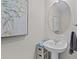 Half bathroom featuring a pedestal sink, framed art and a round mirror at 8401 Riverdale Ln # 8401, Davenport, FL 33896