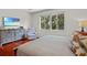 Bright bedroom featuring hardwood floors, a flat screen TV, and view of lush greenery at 8401 Riverdale Ln # 8401, Davenport, FL 33896