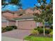 Charming pink two-story home with tile roof, a brick driveway, and manicured landscaping at 8401 Riverdale Ln # 8401, Davenport, FL 33896