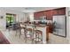A kitchen with an island bar, stainless steel appliances, and dark wood cabinets at 8401 Riverdale Ln # 8401, Davenport, FL 33896