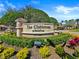 The decorative stone 'Clubhouse at BellaTrae' entrance sign, surrounded by colorful landscaping at 8401 Riverdale Ln # 8401, Davenport, FL 33896