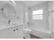 Bright bathroom featuring a tub, white marble tile, and a sleek, modern vanity at 946 Little Creek Rd, Orlando, FL 32825