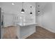 Bright open kitchen featuring an island with pendant lights, white cabinets, and wood floors at 946 Little Creek Rd, Orlando, FL 32825