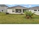 Exterior shot of the backyard featuring a screened-in patio with green grass at 954 Revere Ave, Haines City, FL 33844