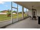 View of screened-in patio features a ceiling fan and table with chairs at 954 Revere Ave, Haines City, FL 33844