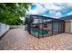 Large backyard featuring a screened pool, brick patio, and white privacy fence, offering a private outdoor retreat at 112 Rosewood Ct, Kissimmee, FL 34743