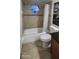 Cozy bathroom featuring a bathtub with shower and hexagon shaped window for natural light at 112 Rosewood Ct, Kissimmee, FL 34743