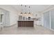 Bright kitchen with island, pendant lighting, white cabinetry and stainless steel appliances at 112 Rosewood Ct, Kissimmee, FL 34743