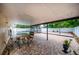Covered outdoor patio with a dining area and an enclosed pool with a slide for relaxing and entertaining at 112 Rosewood Ct, Kissimmee, FL 34743