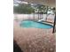 Inviting pool with slide feature and screened enclosure, surrounded by brick-style tiling at 112 Rosewood Ct, Kissimmee, FL 34743