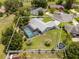 Drone view of a beautiful backyard with a pool, screen enclosure, privacy fence and tropical landscaping at 113 Candlewood Ct, Kissimmee, FL 34743