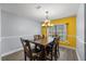 Cozy dining area features a dark wood table, modern lighting, and a bright window at 113 Candlewood Ct, Kissimmee, FL 34743