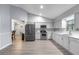 Open kitchen with stainless steel appliances, white cabinetry, and modern flooring at 113 Candlewood Ct, Kissimmee, FL 34743