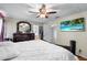Main bedroom with a ceiling fan, TV, dark furniture, and an ensuite bathroom at 113 Candlewood Ct, Kissimmee, FL 34743
