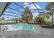 Relaxing screened-in pool area featuring lounge chairs and a tranquil backyard view at 113 Candlewood Ct, Kissimmee, FL 34743