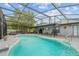 Backyard pool with a screened enclosure and connected patio for outdoor entertainment at 113 Candlewood Ct, Kissimmee, FL 34743